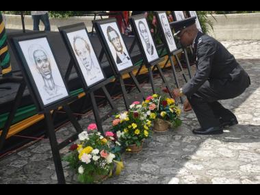 In this file, Superintendent Dolfin Doeman, of the Jamaica Fire Brigade, lays a floral tribute in front of the portrait of national hero George William Gordon, during the annual National Heroes’ Day civic celebration and awards ceremony at Sam Sharpe Squ