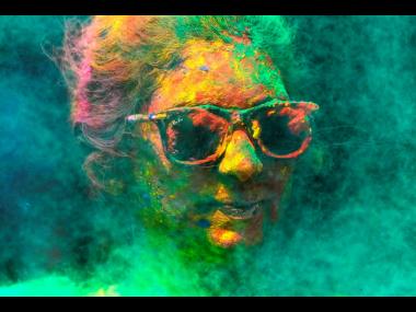 In this 2023 photo, a woman smeared with colours celebrates Holi, in Mumbai, India.