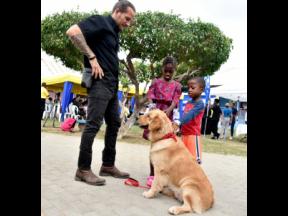 Joseph ‘Joey’ Brown (left), curator of the Hope Zoo, and his Golden Retriever, Dr Teddy Barks, interact with children from the Bustamante Hospital for Children during the launch of animal-assisted recovery care at the hospital on March 28.