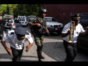 Police escort musicians arriving for the swearing-in ceremony of a transitional council tasked with selecting a new prime minister and cabinet at the Prime Minister’s office in Port-au-Prince, Haiti on Thursday.