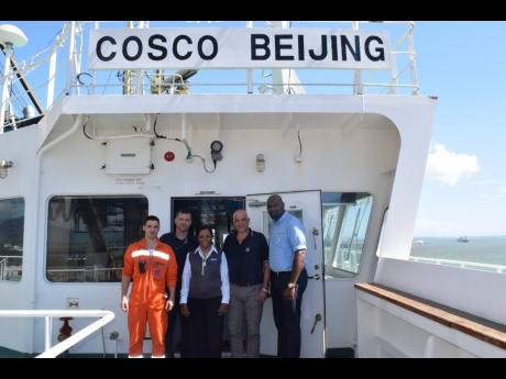 From left: Nikolaos Roumpis, second officer; Athanasios Tsiampas, chief officer; Anna Hamilton, marketing manager at Jamaica Freight Shipping Co. Ltd; Evangelos Benetos, Captain; and Dane McDonald, logistics officer at Jamaica Freight Shipping Co Ltd, on the COSCO Beijing’s during its inaugural call to the port of Kingston.