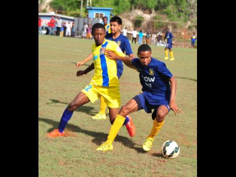 Timar Lewis (right), in his time as a Munro College player, moves away from a tackle from St Elizabeth Technical High School’s Aldane Barrett in their ISSA/Wata daCosta Cup Group E clash at Alpart on Saturday September 19, 2015. File