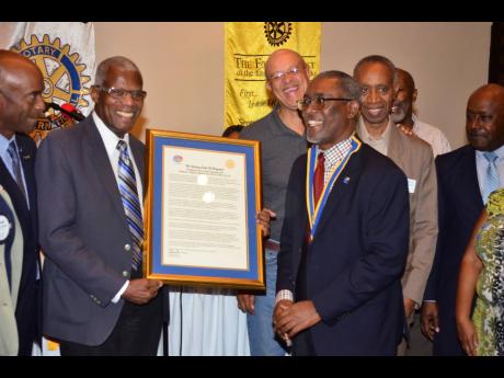 Awardee Aulous Madden (second left) holds the citation while Linval Freeman (right), President of the Rotary Club of Kingston, Raymond Campbell (left) guest speaker, together with chartered accountants who attended in support, enjoy the moment.