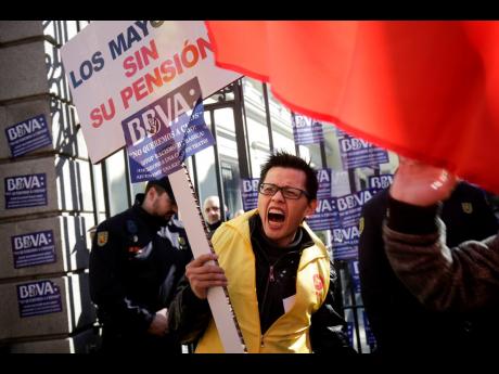 A man protests outside a BBVA bank building in Madrid, Spain, on February 15. Hundreds of Chinese have protested outside a Spanish bank’s premises in Madrid, claiming they are being denied access to their accounts, while the bank insists it is obeying money-laundering laws. AP