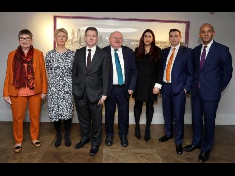 Seven MPs (from left): Ann Coffey, Angela Smith, Chris Leslie, Mike Gapes, Luciana Berger, Gavin Shuker and Chuka Umunna pose for a photograph after a press conference to announce the new political party, The Independent Group, in London on Monday, February 18. 