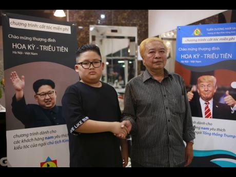Le Phuc Hai, 66 and To Gia Huy, nine, pose for a photo after having Trump and Kim haircuts in Hanoi, Vietnam, on Tuesday.  US President Donald Trump and North Korean leader Kim Jong Un have become the latest style icons in Hanoi, a week before their second summit is to be held in the capital city of Vietnam. 