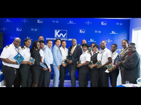 CEO of Kingston Wharves Grantley Stephenson (fifth from left) and Commissioner of Customs Velma Ricketts-Walker (sixth from left) share in the moment with  customs officers, managers and supervisors who were recognised by Kingston Wharves Limited for their services. 