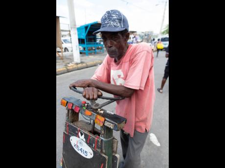 Jonah Wilson pushes his colourful handcart along West Street, Kingston, en route to the market on Friday. Gladstone Taylor/Multimedia Photo Editor