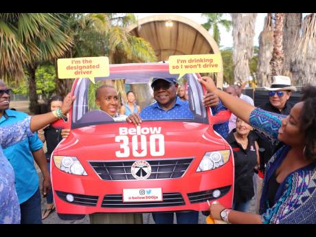 In support of road safety, Tourism Minister Edmund Bartlett and Energy Minister Fayval Williams pose for a photo opportunity at Jamaica Rum Festival, Hope Gardens, St Andrew, on Tuesday.  