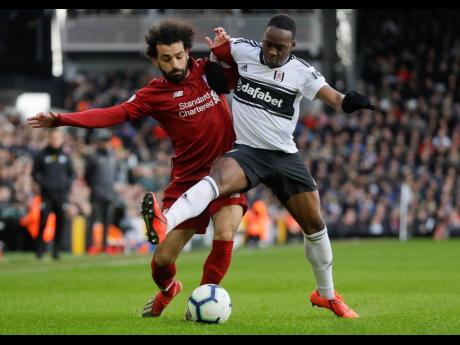 Liverpool’s Mohamed Salah (left) and Fulham’s Neeskens Kebano vie for the ball during their English Premier League match at Craven Cottage stadium in London, yesterday. Liverpool won 2-1.
