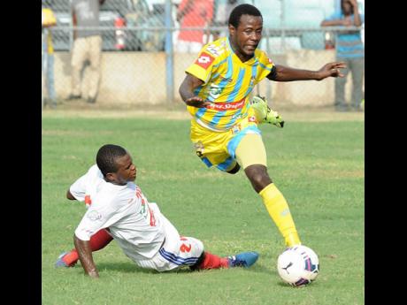 Damarley Samuels (right) from Waterhouse is about to be taken down with a hard sliding tackle from Kemar Phillipott from Portmore United during a Red Stripe Premier League match at the Waterhouse Stadium in 2015.