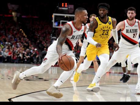 Portland Trail Blazers guard Damian Lillard (left) drives to the basket on Indiana Pacers guard Wesley Matthews during the second half of an NBA basketball game in Portland on Monday night. The Blazers won 106-98. 