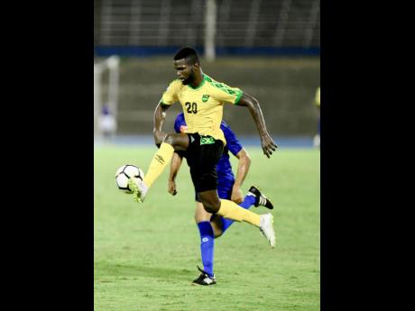 Jamaica’s Kemar Lawrence (foreground) takes the ball under control while being chased by Cayman Islands defender Kyle Santamaria during their CONCACAF Nations League game at the National Stadium on Sunday, September 9, 2018. 
