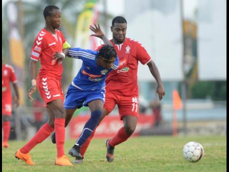 Mount Pleasant FA’s Daniel Green (centre) drives forward, riding the challenge of UWI FC defenders Rochane Smith (left) and Dwayne Smith during the first leg of their Red Stripe Premier League quarter-final match-up at the Anthony Spaulding Sports Complex yesterday. 