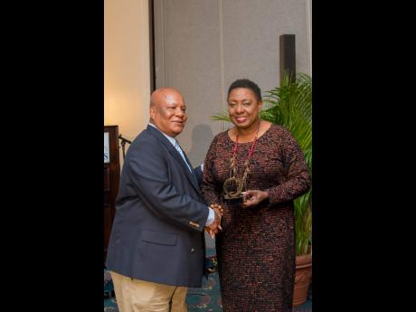 Anthony Richards of Trojan Records presents his Q Awards to Minister of Culture, Gender, Entertainment and Sport Olivia Grange.
