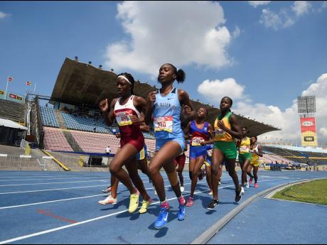 Samantha Pryce, 4:52.09, (foreground left) of Holmwood Technical on her way to winning Heat Two of the Class Two girls 1500m event at the ISSA/GraceKennedy Boys and Girls Athletics Championships at the The National Stadium yesterday. 