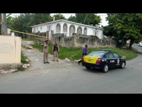 
Police personnel at the crime scene in Rose Heights, St James, yesterday where five persons were shot, two fatally.