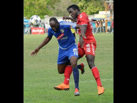 Mount Pleasant FA’s Francois Swaby (left) and UWI FC’s Michael Heaven (right) tussle for ball possession during the second-leg quarter-final tie of the Red Stripe Premier League at Drax Hall, St Ann, yesterday. 