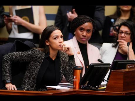 House Oversight and Reform Committee members, from left, Rep Alexandria Ocasio-Cortez, D-NY, Rep Ayanna Pressley, D-Mass, and Rep Rashida Tlaib, D-Mich, listen during a committee hearing on Capitol Hill in Washington, Tuesday, Februrary 26, 2019. Ocasio-Cortez and others in the Democratic party are being labelled socialists in a derogatory criticism of policies they are advancing on climate change and health.