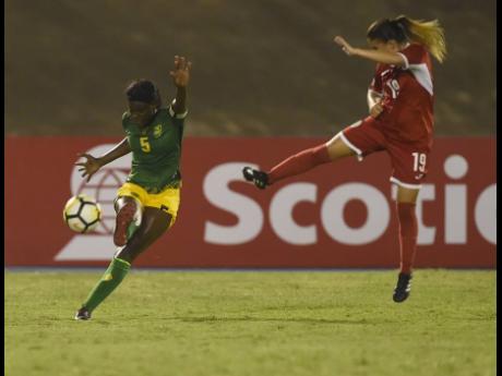Captain Konya Plummer (left) makes a clearance as Cuba’s Yennifer Ramos Lopez lunges in during Jamaica’s FIFA Women’s World Cup qualifying game at the National Stadium in Kingston on Sunday, September 2, 2018. 
