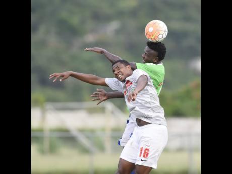 Ladale Richie of Mount Pleasant Football Academy heads the ball over Andrae Bernal of UWI FC (front) during a Red Stripe Premier League match at University of the West Indies last season.