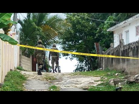 Soldiers make their way to an area where five persons were shot, two fatally, in Rose Heights, St James, last month.