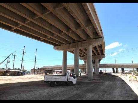A  motorist drives a small truck  under a section of the new Three Miles interchange, which should be completed by December 2019.
