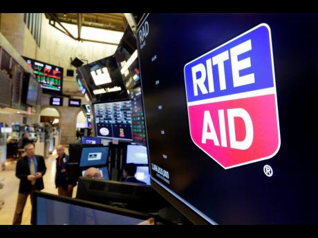 The logo for Rite Aid is displayed above a trading post on the floor of the New York Stock Exchange.
