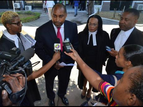 People’s National Party General Secretary Julian Robinson speaks with the media following yesterday’s court ruling. Looking on are (from left) attorney-at-law Jennifer Housen; Donna Scott Mottley, the opposition spokesman on justice; and PNP Vice-President Phillip Paulwell.