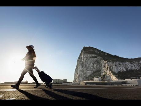 A woman walks on the Spanish side of the border between Spain and the British overseas territory of Gibraltar, one of the territories for which Brexit has brought uncertainty. But as the UK slow walks its way out of EU membership, there is movement on a new trade partnership agreement that it hopes to negotiate with Caribbean members of Cariforum.