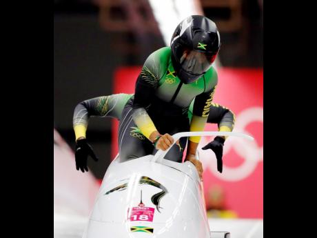 
Driver Jazmine Fenlator-Victorian (front) settles into the sled during Jamaica’s first heat in the women’s two-man bobsled competition at the 2018 Winter Olympics in Pyeongchang, South Korea, Tuesday, February 20, 2018. 