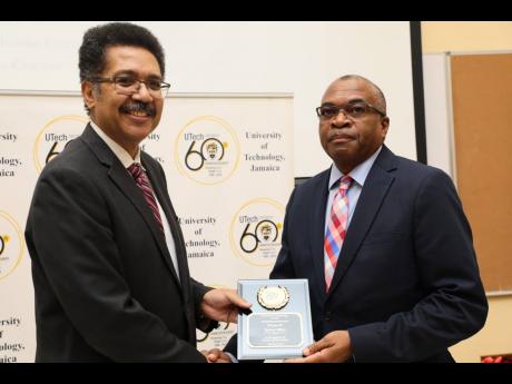 Professor Stephen Vasciannie, president, UTech, Jamaica, presents the Outstanding Alumni Award for Service to Country to Trevor Riley, group CEO  of the Shipping Association of Jamaica.