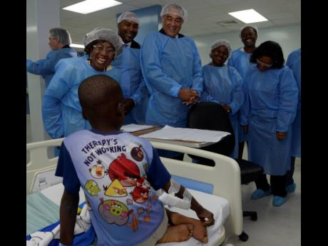From left: Dr Venice Guntley McKenzie (left); Member of Parliament Julian Robinson; Health Minister Dr Christopher Tufton; and Digicel Foundation CEO Karlene Dawson speak with a young patient at the newly opened cardiac centre at the Bustamante Hospital for Children yesterday.