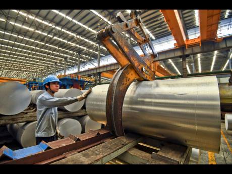 In this Wednesday, April 10 photo, a worker transfers an aluminium product at a factory in Nanning in south China’s Guangxi Zhuang Autonomous Region.