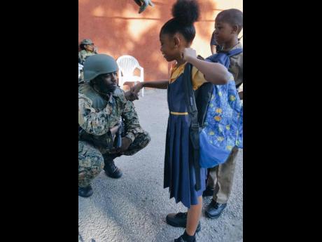 A member of the joint security forces interacts with children in Mount Salem, St James, in this 2017 file photo.