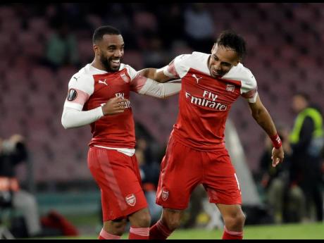 Arsenal's Alexandre Lacazette (left) celebrates after scoring his side's first goal during the Europa League second leg quarter-final match between Napoli and Arsenal at San Paolo stadium in Naples, Italy, yesterday.