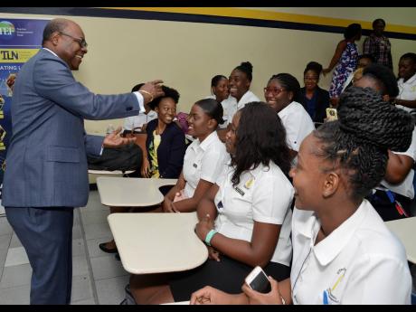 Tourism Minister Edmund Bartlett congratulates graduates at the Jamaica Blue Mountain Coffee Festival Volunteer Programme during the awards ceremony at the University of Technology, Jamaica, on Tuesday.