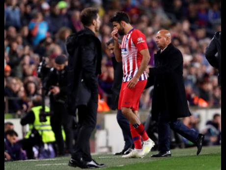 Atletico forward Diego Costa walks off the pitch after receiving a red card for insulting referee Jesus Gil Manzano during a Spanish La Liga match between FC Barcelona and Atletico Madrid at the Camp Nou stadium in Barcelona, Spain, Saturday, April 6. 