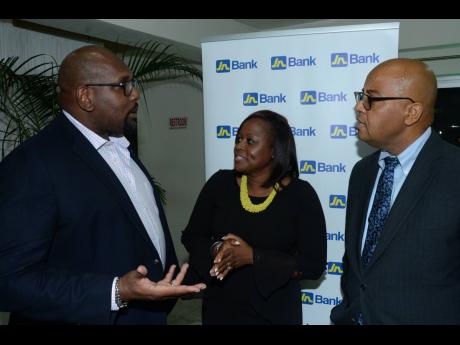 Gladstone Whitelocke (right), Development Financing Specialist, Jamaica National Group, and Petal James (centre), head of Mobile Banking, JN Bank, listen keenly as Andrew James, president of the Realtors’ Association of Jamaica (RAJ), makes a point, during the ‘Know Your Property Rights’ symposium, mounted by the RAJ at the Golf View Hotel in Mandeville recently. The event was sponsored by JN Bank.