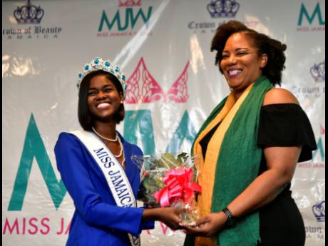 Miss Jamaica World franchise holder Dahlia Harris is presented with a bouquet by Miss Jamaica World 2018 Kadijah Robinson at the launch of Miss Jamaica World 2019 at The Jamaica Pegasus hotel in New Kingston last Thursday. 