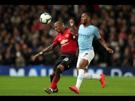 Manchester City’s Raheem Sterling (right) fights for the ball with Manchester United’s Ashley Young during the English Premier League match between Manchester United and Manchester City at Old Trafford Stadium in Manchester, England, yesterday. City won 2-0. 