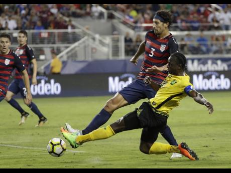 Jamaica's Darren Mattocks (right) tackles the US' Omar Gonzalez during the second half of the CONCACAF Gold Cup final in Santa Clara, California on July 26, 2017. 
