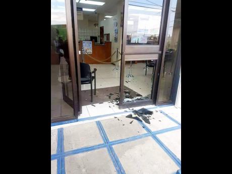 The broken glass of the entrance door to one of the banks. 