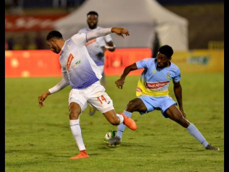 Waterhouse FC's Stephen Williams (right) twists and turns away from Portmore United's Osani Williams' challenge during the first half of their Red Stripe Premier League (RSPL) final clash at the National Stadium last night. 