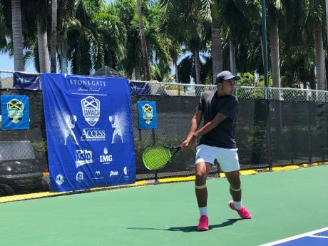 Jamaican player John Chin makes a return along the baseline during his Second Round match against Caymus Hei Tung Choi from USA in the ITF Jamaica Cup tournament on Tuesday at the Half Moon Resort in Montego Bay. 