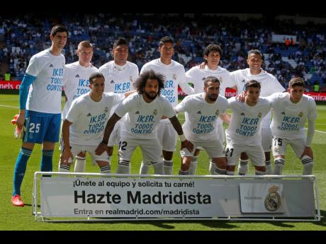 Real Madrid players pose with shirts supporting former club goalkeeper Iker Casillas before a LaLiga match against Villarreal at Estadio Santiago Bernabeu in Madrid, Spain, yesterday. The shirts read ‘Iker, we are all with you’ after Casillas suffered a heart attack while training with Porto on Wednesday.