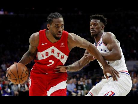 Toronto Raptors’ Kawhi Leonard (left) drives against Philadelphia 76ers’ Jimmy Butler during the second half of Game Four of a second-round NBA play-off series in Philadelphia yesterday. The Raptors won 101-96. 