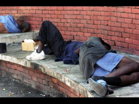 Two homeless men asleep on a platform at the Sir William Grant Park in downtown Kingston.