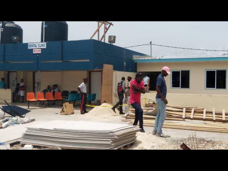 Police investigators at the construction site where a disgruntled employee opened fire on two colleagues at the Cornwall Regional Hospital in Mount Salem, St James, yesterday.