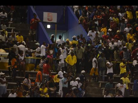 Spectators caught up in a missile throwing incident at the National Stadium, during the Red Stripe Premier League final between Portmore United and Warterhouse FC on Monday, April 29.  